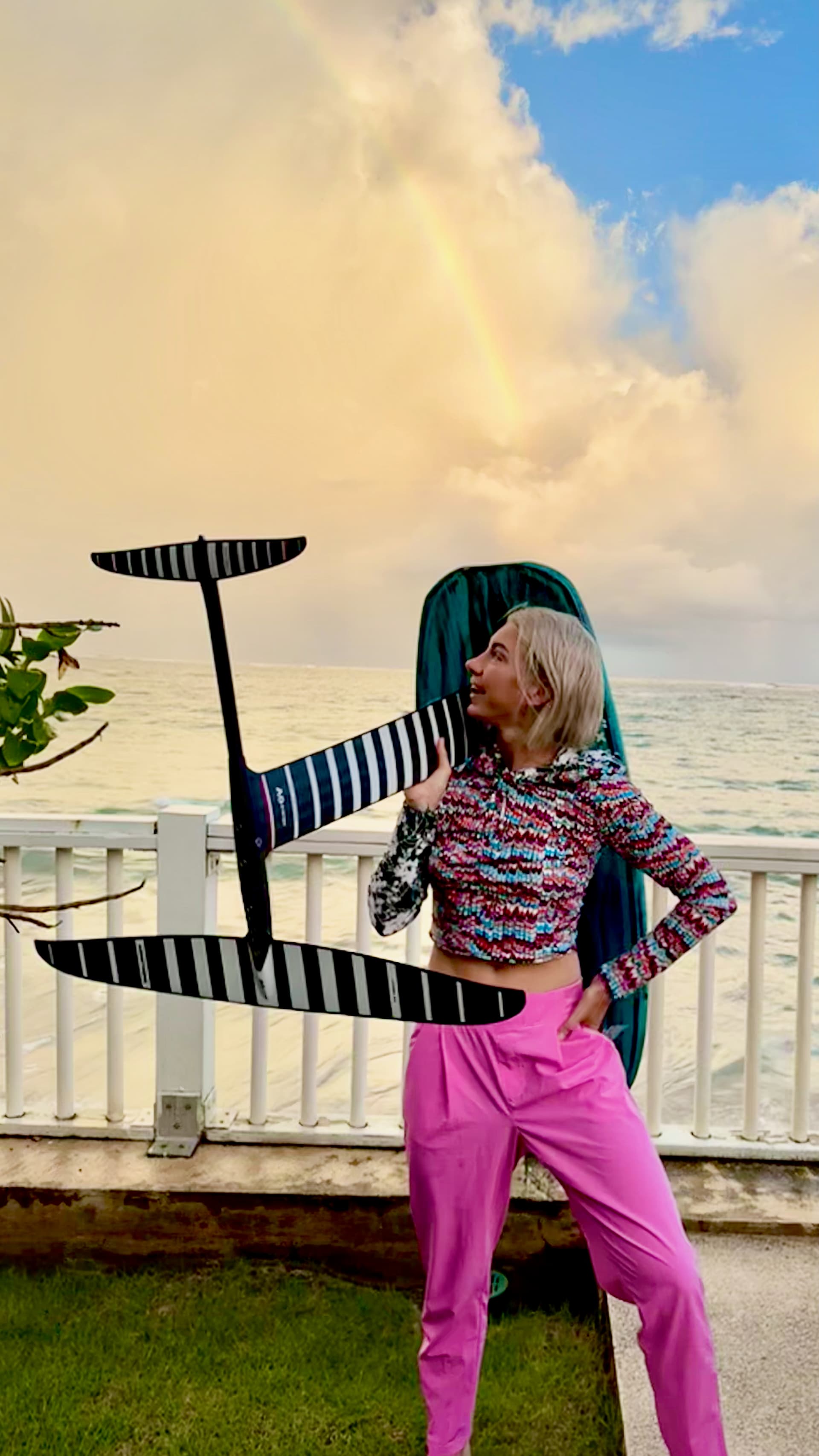 Wren Dougherty carrying foiling gear by the water